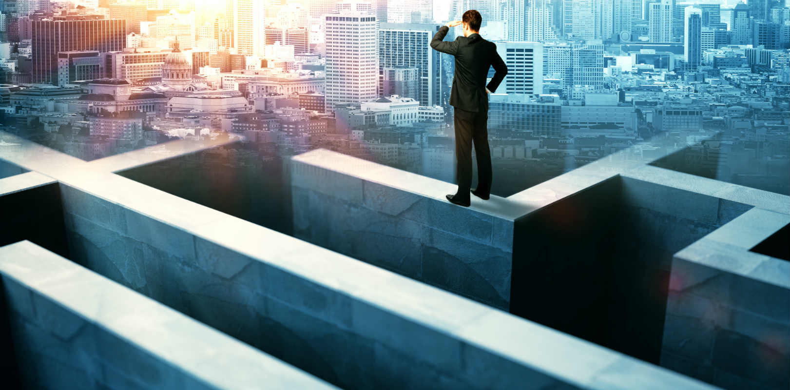 Businessman navigating maze above high rise buildings