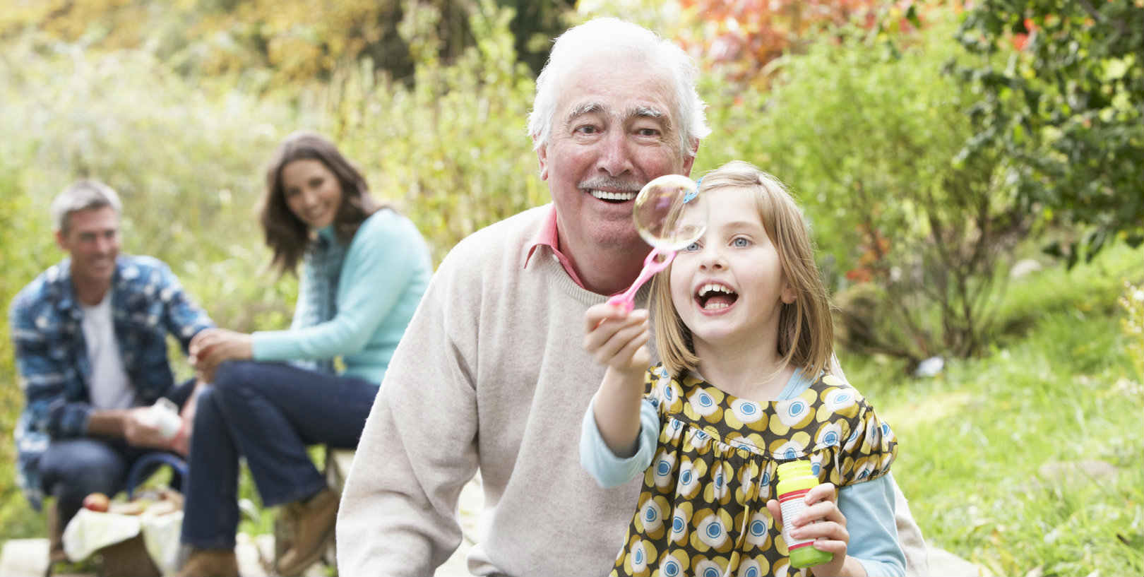 Elderly man in carehome garden playing with grandchild